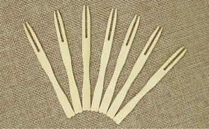 Detailed top view of eco-friendly bamboo fruit forks arranged on a rustic burlap fabric