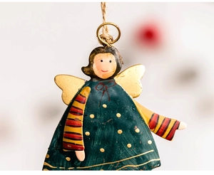 Close-up of vintage iron Christmas angel pendant with painted details and hemp rope