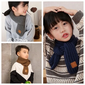Detailed knit texture of children's winter scarves in gray, brown, and navy blue