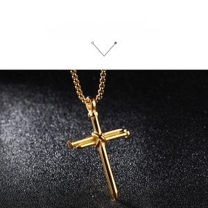 Macro detail of gold stainless steel cross necklace made of two interlocking nails