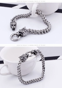 Macro detail of retro stainless steel woven chain bracelet with dual wolf head charms