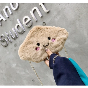 Close-up of beige plush cloud bag featuring cute embroidery and elegant gold chain strap