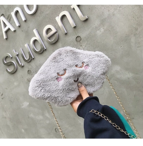 Detail of grey plush cloud bag featuring closed-eye embroidery and golden metal chain