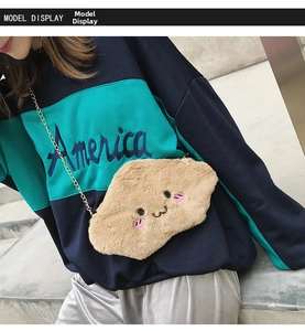 Detailed model shot of light brown plush cloud crossbody bag with embroidered face and chain