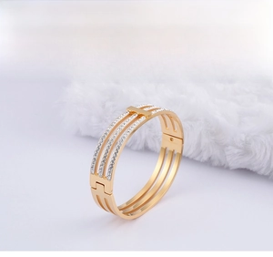 Detail of three-layer gold-plated stainless steel bracelet with inlaid white crystals