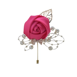 Detail of fuchsia silk rose wedding boutonniere with golden leaves and pearl accents