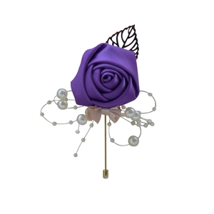 Detail of purple satin rose boutonniere with elegant white pearls and a golden pin