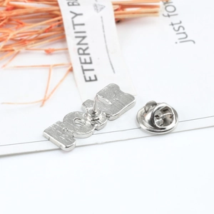Detailed back view of silver MOM letter brooch showing brushed metal and butterfly clasp