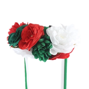 Close-up of red, white, and green artificial flowers on headband with green ribbons