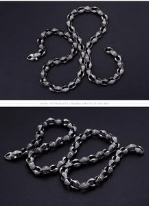 Macro shot of silver titanium necklace with textured olive-shaped links on black leather