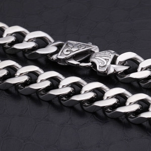 Polished silver stainless steel cuban curb chain for men on black leather texture background