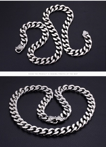 Detail of silver heavy Cuban link chain with vintage engraved fleur-de-lis clasp