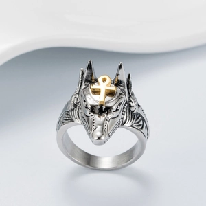 Détail macro de la bague tête d'Anubis avec symbole Ankh doré et finition argent oxydé