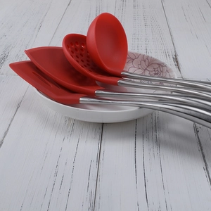 4-piece red silicone and stainless steel kitchen utensil set in a white ceramic bowl