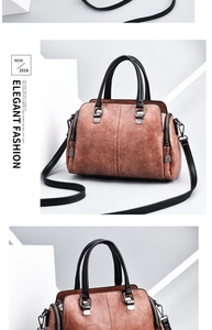 Close-up of brown textured PU leather handbag with black handles and side zippers
