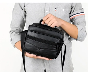 Detailed close-up of a black leather business laptop bag with adjustable shoulder straps