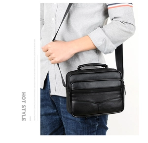 Black leather business bag with top handle and zippers shown on a male model