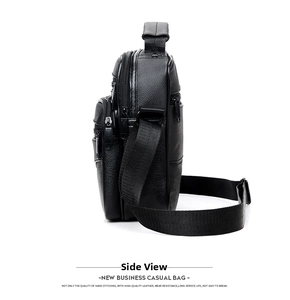 Detailed side view of black pebble grain leather messenger bag with multiple zippers