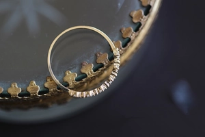 Close-up of gold s925 silver ring with micro-pave cubic zirconia on vintage glass edge