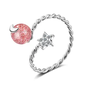 Adjustable strawberry quartz ring with silver moon and star accents on white background