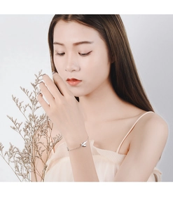 Silver butterfly bracelet on wrist with delicate chain and sparkling charms