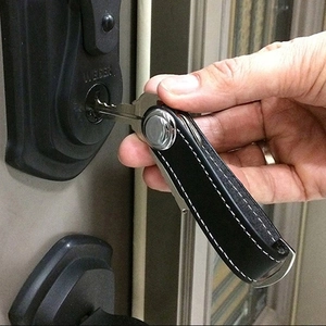Creative black leather key organizer with white stitching and metal hardware in use