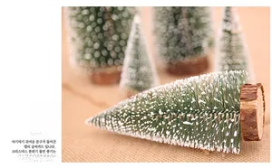 Close-up of mini sisal Christmas trees with snow tips and natural wood base on burlap