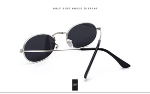 Side angle view of retro oval sunglasses with slim silver metal frame and dark gray lenses