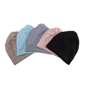 Gorros de punto transpirables en cinco colores variados sobre un fondo blanco limpio