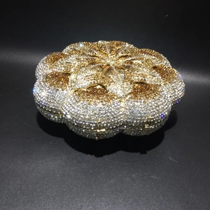 Macro shot of rose flower evening clutch with gold and amber crystals on black background