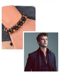 Detail of double-layer bracelet with tiger eye beads and matte black stones on a male wrist