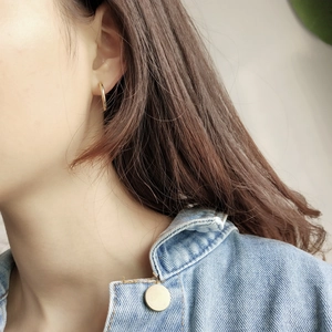 Detailed view of irregular minimalist 925 silver gold-plated hoop earrings on a model