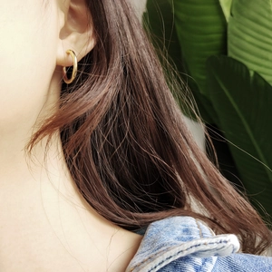 Close-up of model wearing gold polished hoop earrings for a stylish daily lifestyle look