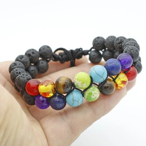 Detailed view of dual-layer woven bracelet with matte stones on a person's hand