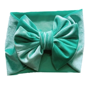 Detail of teal velvet baby headband featuring a soft texture and a large decorative bow