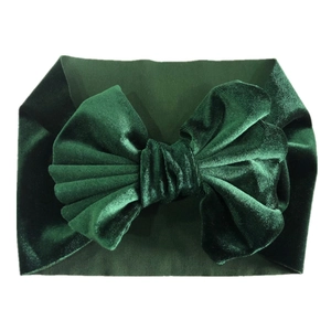 Detail of soft dark green velvet baby headband featuring a large textured bow design