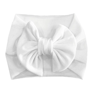 Detailed macro view of a soft white velvet baby headband with a large decorative bow