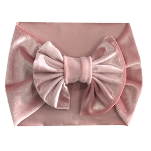 Detailed close-up of soft dusty pink velvet baby headband with a large bow decoration