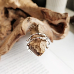 Macro shot of silver bamboo joint double-layer adjustable open ring on a wooden branch