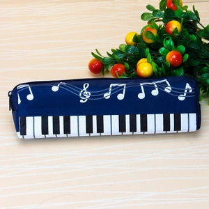 Detail of music-themed pencil case featuring white notes and piano keys on blue canvas