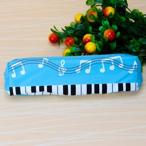 Close-up of blue piano note pencil case with keyboard design on wooden background