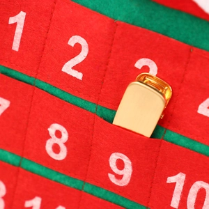Polished gold metal clip displayed in a festive red and green felt advent calendar pocket