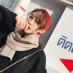 Detail of warm knit scarf and red headband with thick texture on cable knit sweater