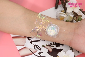 Macro shot of iridescent white chunky glitter gel on skin for festive makeup looks