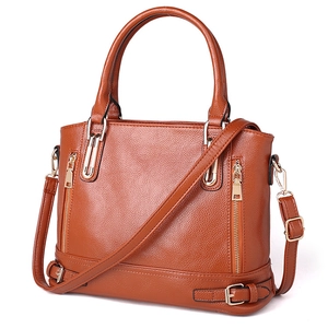 Detail of vintage brown leather tote bag with gold hardware and removable shoulder strap