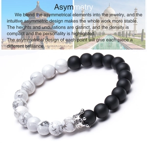 Detail of 8mm white turquoise and matte black stone bracelet with silver crown charm