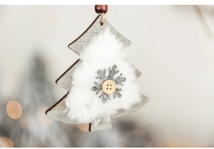 Detail of wooden Christmas tree ornament with faux fur, felt snowflake and bead