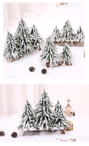 Miniature snowy Christmas trees on a wooden base with festive winter scene props