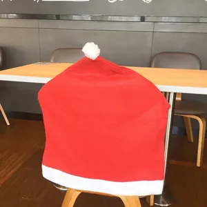 Detail of red Santa hat chair cover in non-woven fabric for Christmas table decor