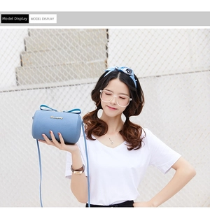 Light blue cylindrical crossbody bag with lychee texture and golden logo detail
